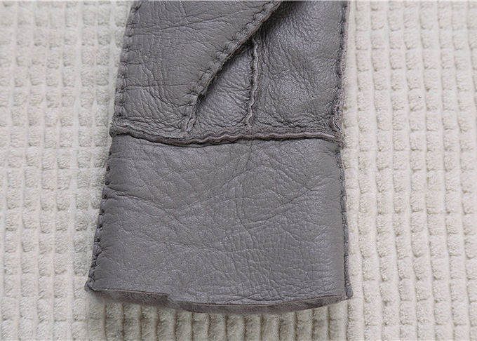 Machen wirklicher Pelz gezeichnete graue wärmste Schaffell-Handschuhe Oberfläche mit dem Finger glatt